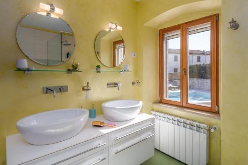 a bathroom with two sinks and a mirror at Casa Jagoda in Višnjan