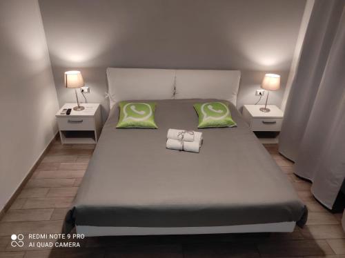 1 cama con 2 almohadas verdes y 2 mesas en Guest House Web Room, en Pisa