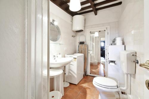 een witte badkamer met een toilet en een wastafel bij One bedroom apartement with wifi at Roccastrada in Roccastrada