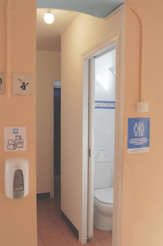 a bathroom with a toilet and a sign on the wall at Hostal l'Estrella in Palafrugell