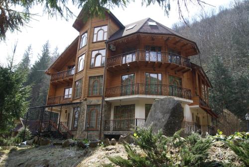 a large wooden house on top of a hill at Hotel Dykyi Med in Tatariv