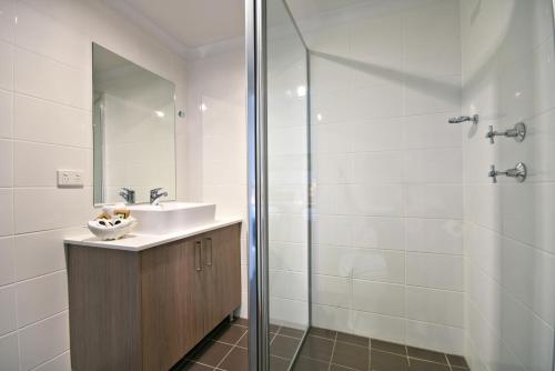 a bathroom with a sink and a shower at The Aberdeen Motel in Dubbo