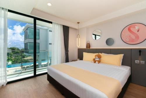 a bedroom with a large bed and a large window at Wekata Luxury in Kata Beach