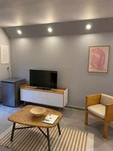 a living room with a tv and a coffee table at Marion Apartments in Kourouta