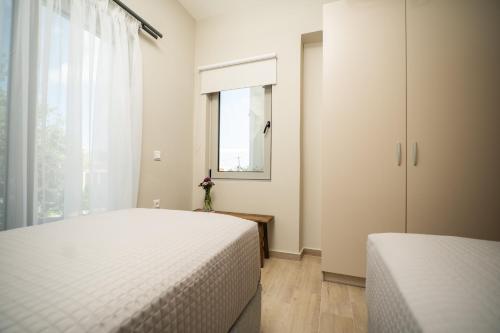 a bedroom with two beds and a window at Villa Oliveto in Tavronitis