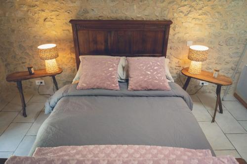 - une chambre avec un lit et 2 lampes sur 2 tables dans l'établissement Les 3 C, à Eymet