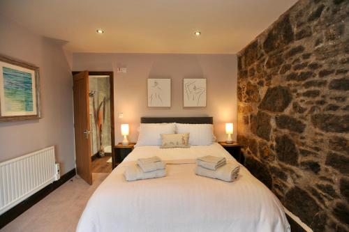 a bedroom with a large bed with towels on it at Beach View in Benllech