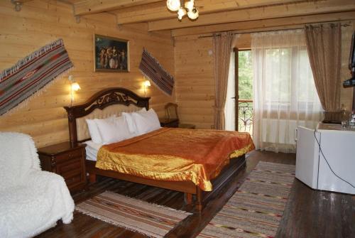 a bedroom with a bed in a log cabin at Hotel Dykyi Med in Tatariv