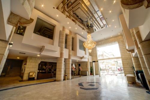 a large lobby with a chandelier in a building at Crystal Hotel in Aqaba