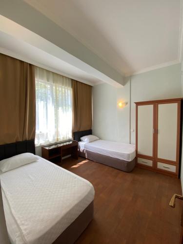 a hotel room with two beds and a window at Erol Apart in Kemer