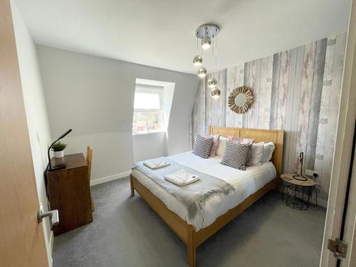 a bedroom with a bed with two towels on it at Coastline Retreats - Newly Refurbished Town centre, Close to beach, Large Jet bath with TV, Netflix, swing and we pay parking in Bournemouth