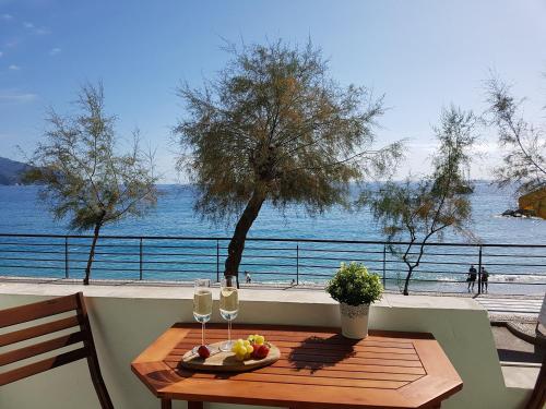 a table with a plate of fruit and two glasses of wine at Mori's Beautiful Sea front Apartment - With A.C. in Monterosso al Mare