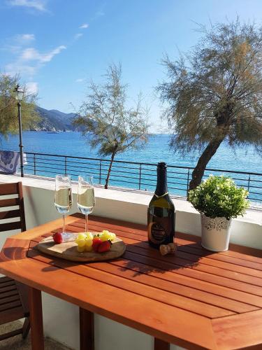 a table with a bottle of wine and two glasses at Mori's Beautiful Sea front Apartment - With A.C. in Monterosso al Mare