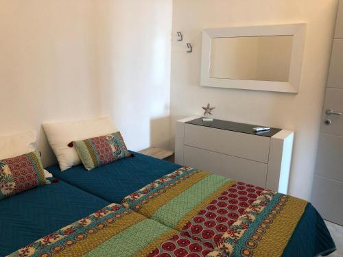 a bedroom with a bed with a dresser and a mirror at Mori's Beautiful Sea front Apartment - With A.C. in Monterosso al Mare