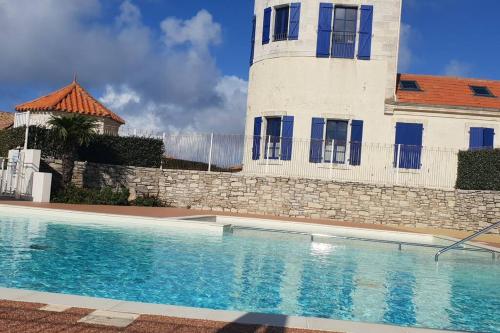 une maison avec piscine devant un immeuble dans l'établissement Les belles papottes, à La Chaume