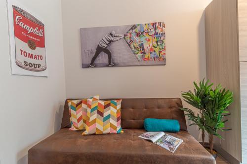 a brown couch in a living room with a painting on the wall at Galvani Apartments in Terni