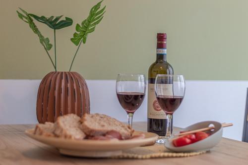 a table with a plate of bread and two glasses of wine at Galvani Apartments in Terni