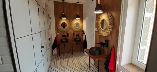 a hallway with two mirrors on the wall and a table at Kraków Chilli Hostel in Kraków