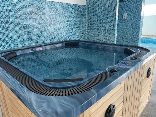 a jacuzzi tub in a bathroom with blue tiles at Resort SPA Clisura Dunarii in Eşelniţa
