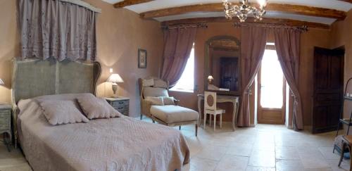 a bedroom with a bed and a chandelier at Clos de Raveyron in Vallon-Pont-dʼArc