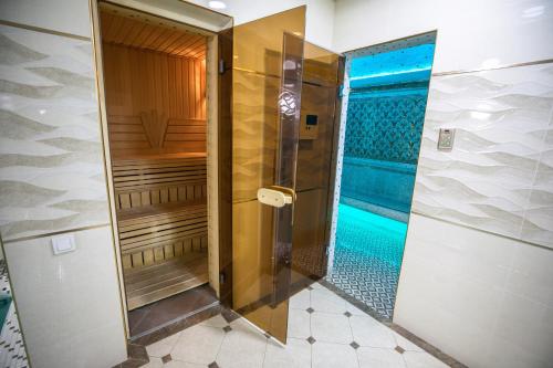 een badkamer met een douche en een zwembad bij Leader Hotel in Tasjkent