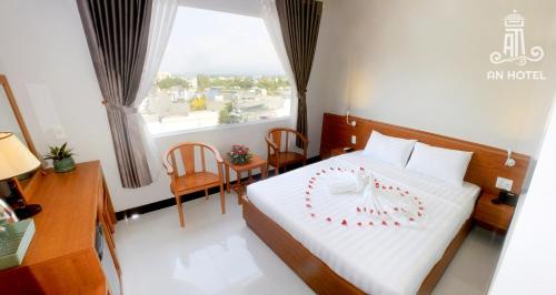 a bedroom with a bed and a large window at An Hotel Phan Thiết in Phan Thiet