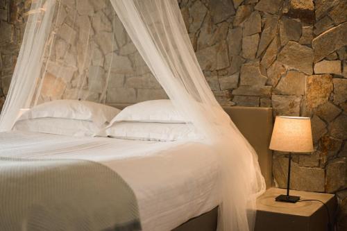 a bedroom with a bed with a mosquito net at Monte Gois Country House e Spa in Curvatos