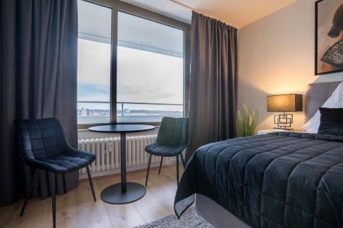 um quarto de hotel com uma cama e uma grande janela em RüSuite - Gemütliches Apartment in Rüttenscheid em Essen