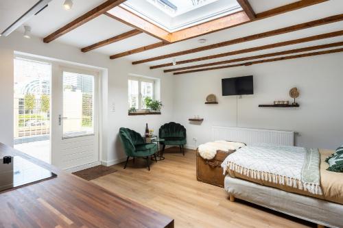 a bedroom with a bed and a desk and a tv at Cottage 44 - Free parking! in Zandvoort