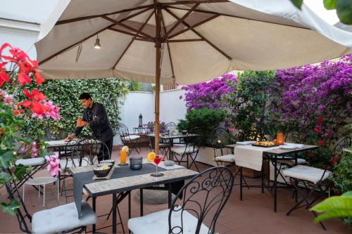 a man sitting at a table under an umbrella at Alpi Hotel in Rome