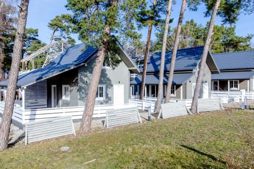 a house with solar panels on its roof at OŚRODEK KOLONIJNO WCZASOWY MEWA - przy plaży z basenem z podgrzewaną wodą i mini SPA in Niechorze