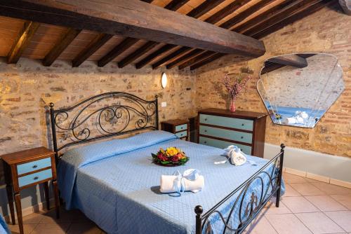 a bedroom with a bed with a blue comforter at Country House Podere Lacaioli in Castiglione del Lago