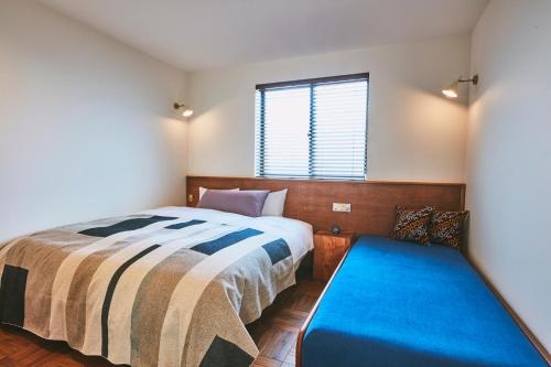 a bedroom with a bed and a blue bench at THE FLOW KAMAKURA in Kamakura