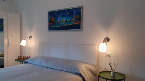 sypialnia z łóżkiem z dwoma światłami i obrazem na ścianie w obiekcie Casa Chiocconi w mieście La Spezia