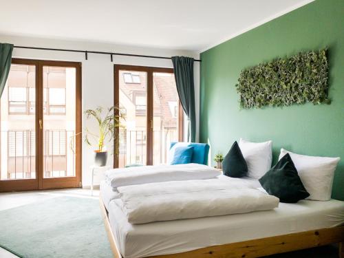1 dormitorio con 2 camas y pared verde en Apollo Apartments, en Núremberg