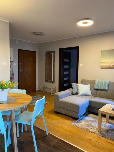 a living room with a couch and a table and chairs at Apartament BalticPark Stegna in Stegna