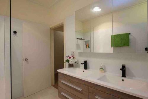 baño con lavabo blanco grande y espejo en Victoria House- Great location, en Corowa