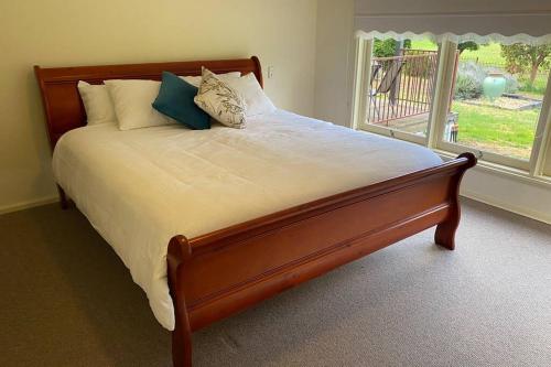 a bed in a bedroom with a large window at Victoria House- Great location in Corowa