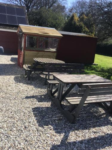 a picnic table and a bench next to a house at B&B Dorwyn Manor in Avebury