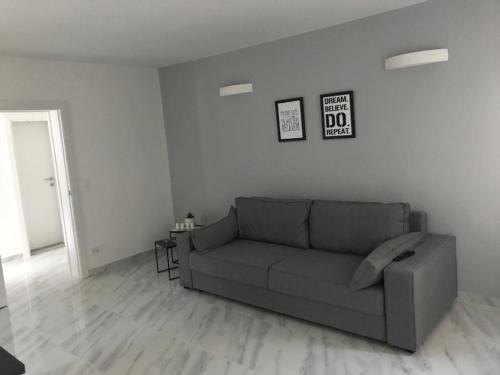 - un salon blanc avec un canapé gris dans l'établissement Casa Bianca, à Herceg-Novi