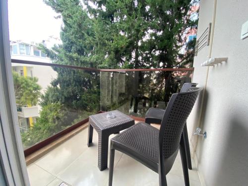 a balcony with two chairs and a table and a window at Elanis Suites in Antalya