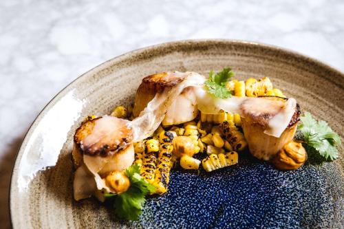 a plate of food with meat and corn on a table at Hyatt Regency Calgary in Calgary