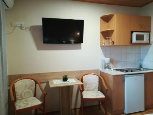 - une petite cuisine avec une petite table et deux chaises dans l'établissement Apartman Mercédesz I., à Zalakaros