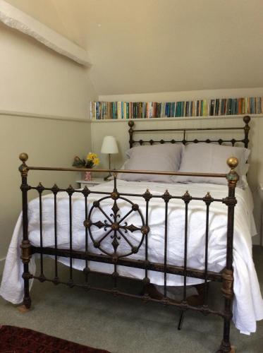 a bedroom with a large bed with white sheets at Wrenscott in Chagford