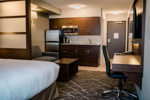 a hotel room with a bed and a desk at Microtel Inn and Suites by Wyndham Portage La Prairie in Portage La Prairie