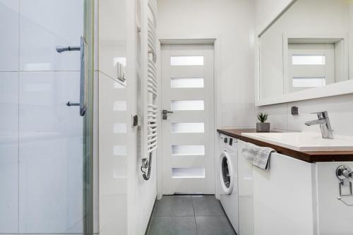 ソポトにあるMonte Apartmentの白いバスルーム(シャワー、シンク付)
