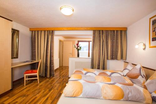 a bedroom with a bed and a desk and a window at Familienferienhaus Florentine in Längenfeld