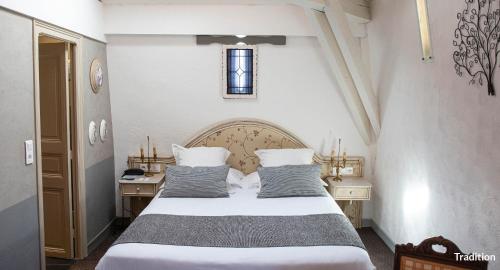 a bedroom with a bed and two tables and a window at Hôtel La Casa Pairal in Collioure