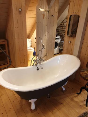 eine große Badewanne in einem Zimmer mit Holzböden in der Unterkunft Ferienhaus auf 2 Etagen mit überdachter Terrasse in Graal-Müritz