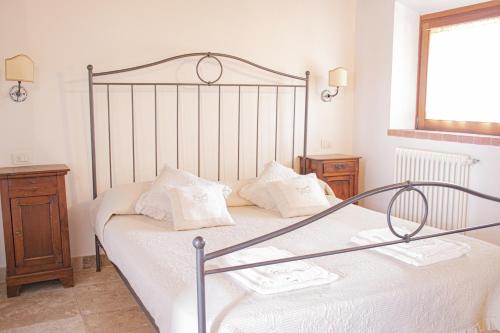 サン·ヴィンチェンツォにあるCasa AUREA Tre Posti Letto a 30 metri dal Mareのベッドルーム1室(金属製ベッド1台、白いシーツ、枕付)